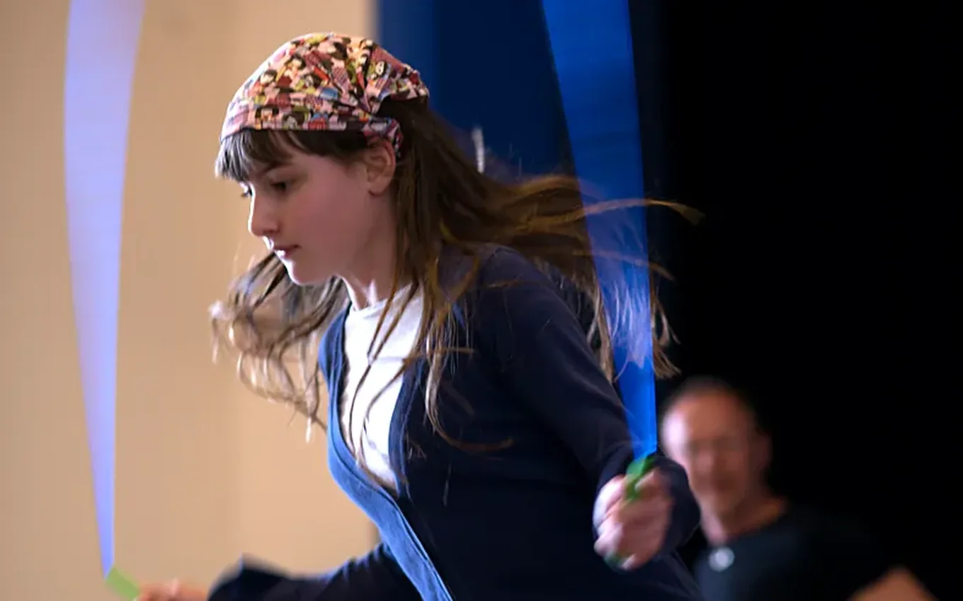 A girl jumps high as her skipping rope spins